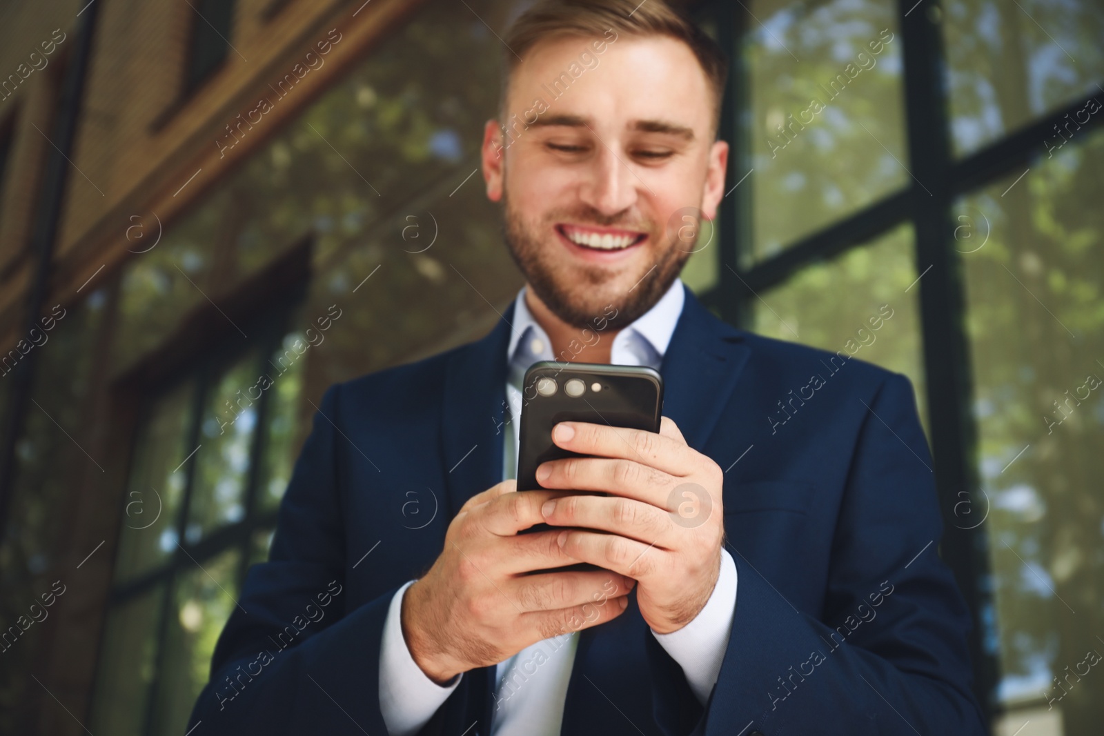 Photo of Young man using smartphone outdoors, focus on hands