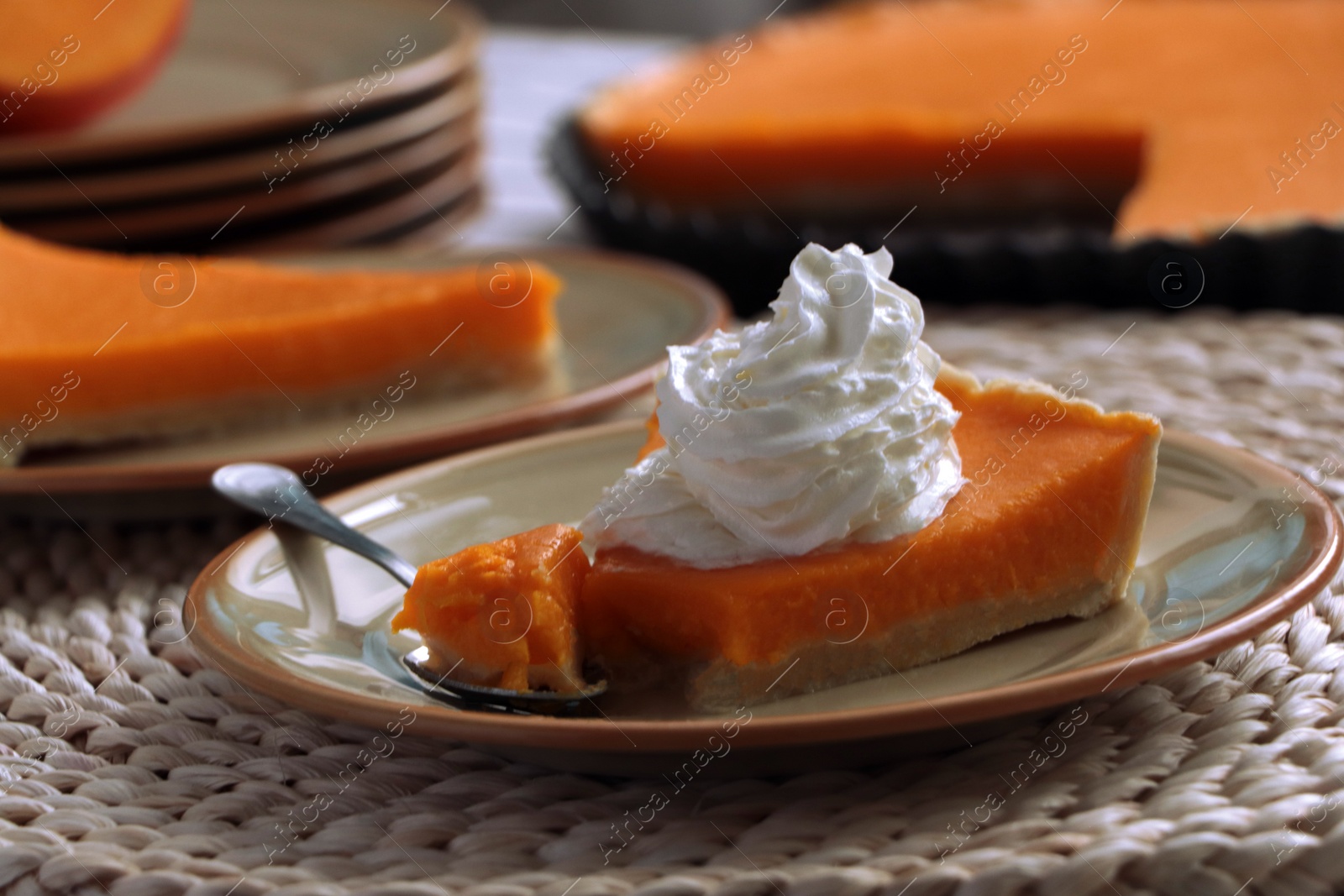 Photo of Piece of fresh homemade pumpkin pie with whipped cream on table