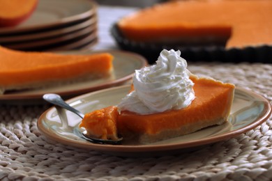 Photo of Piece of fresh homemade pumpkin pie with whipped cream on table