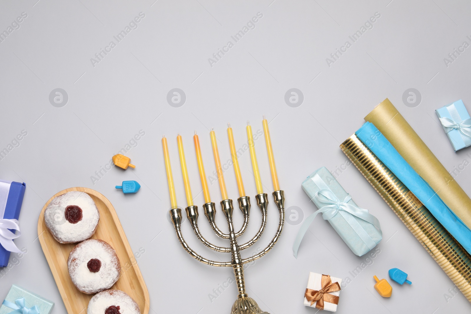 Photo of Flat lay composition with Hanukkah menorah and gift boxes on light grey background. Space for text