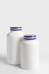 Photo of Closed plastic medicine bottles on white background. Medicament