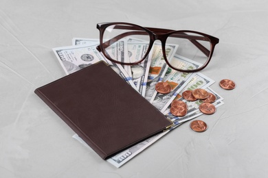 Pension certificate with American money and glasses on grey stone background