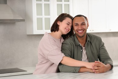 Photo of Dating agency. Woman embracing her boyfriend in kitchen, space for text