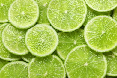 Fresh sliced ripe limes as background, top view