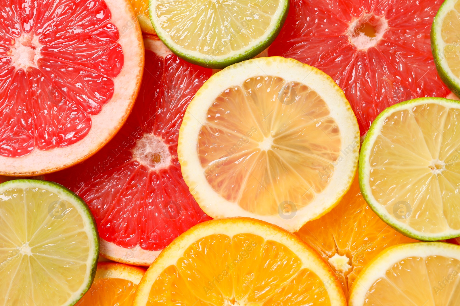 Photo of Different sliced citrus fruits as background, top view