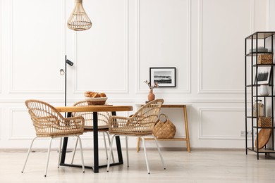 Dining room interior with wooden table and wicker chairs