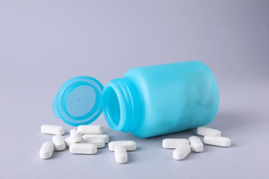 Photo of Antidepressants and medical jar on light grey background