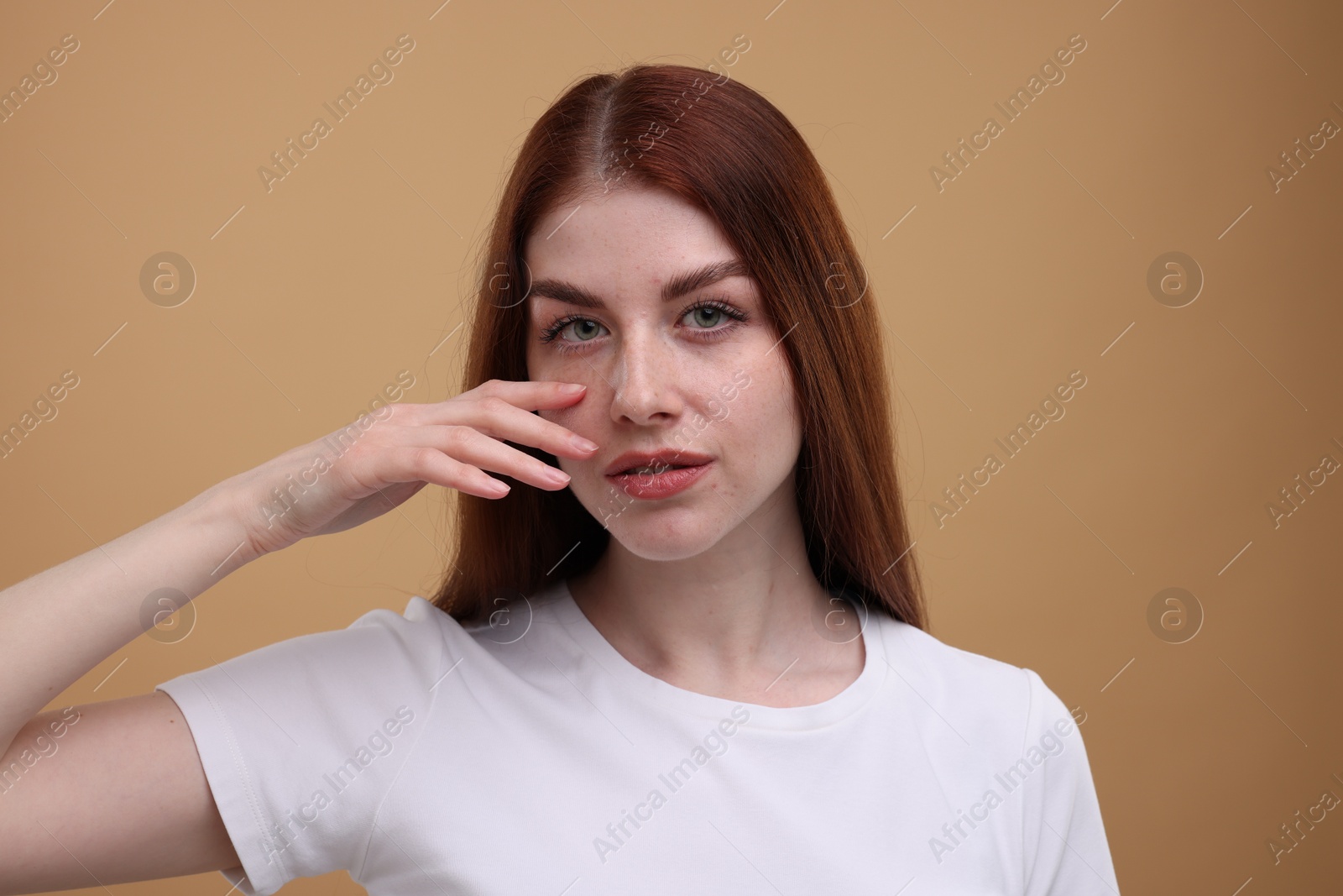 Photo of Portrait of beautiful woman with freckles on beige background