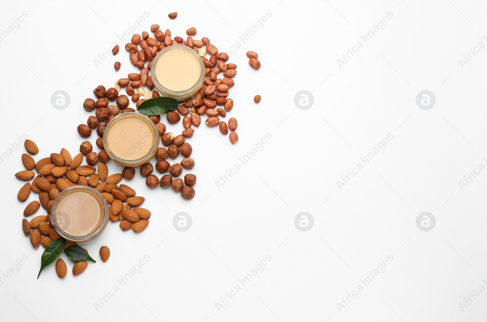 Photo of Different types of delicious nut butters and ingredients on white background, top view