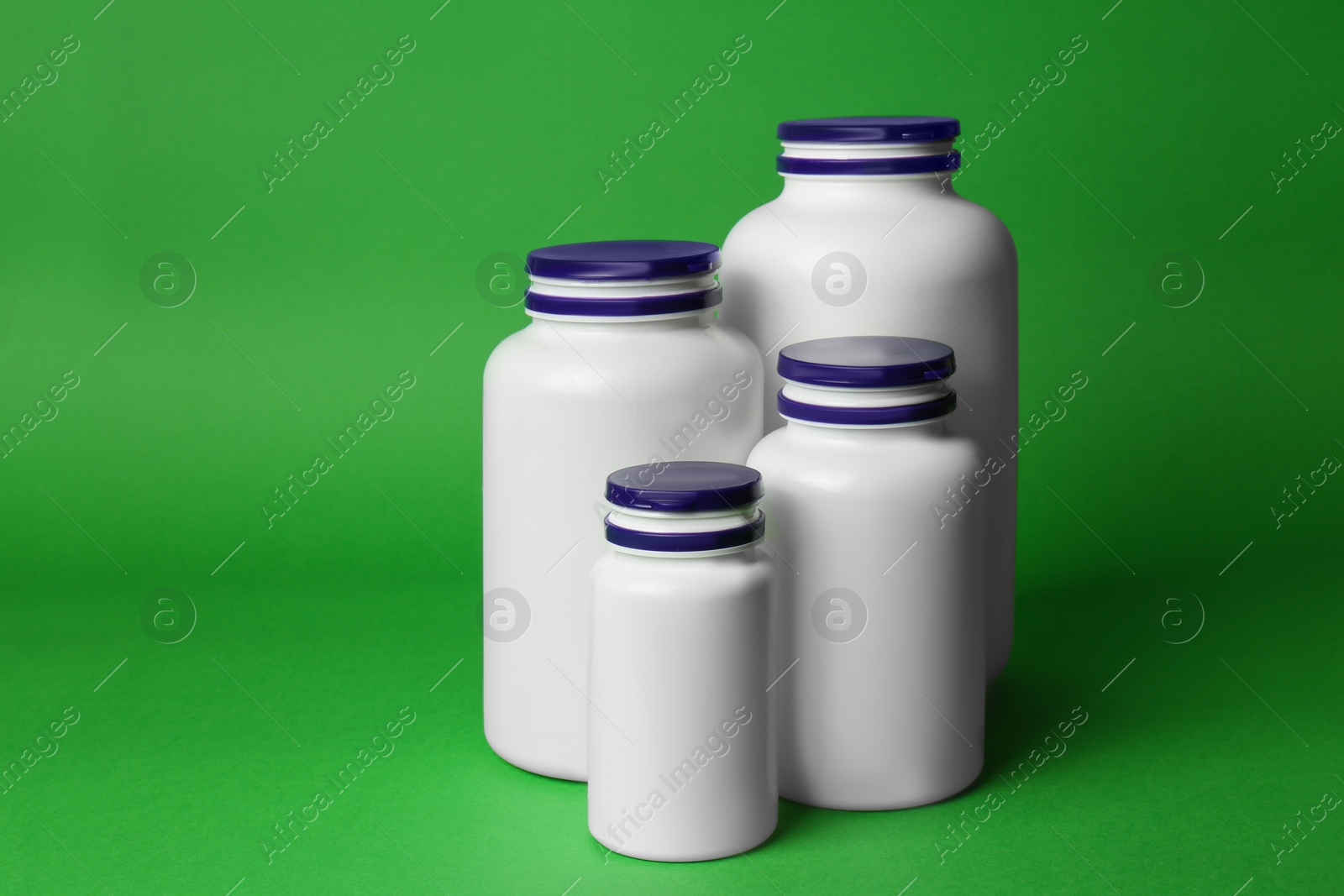 Photo of Many different plastic medicine bottles on green background. Medicament