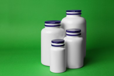 Photo of Many different plastic medicine bottles on green background. Medicament