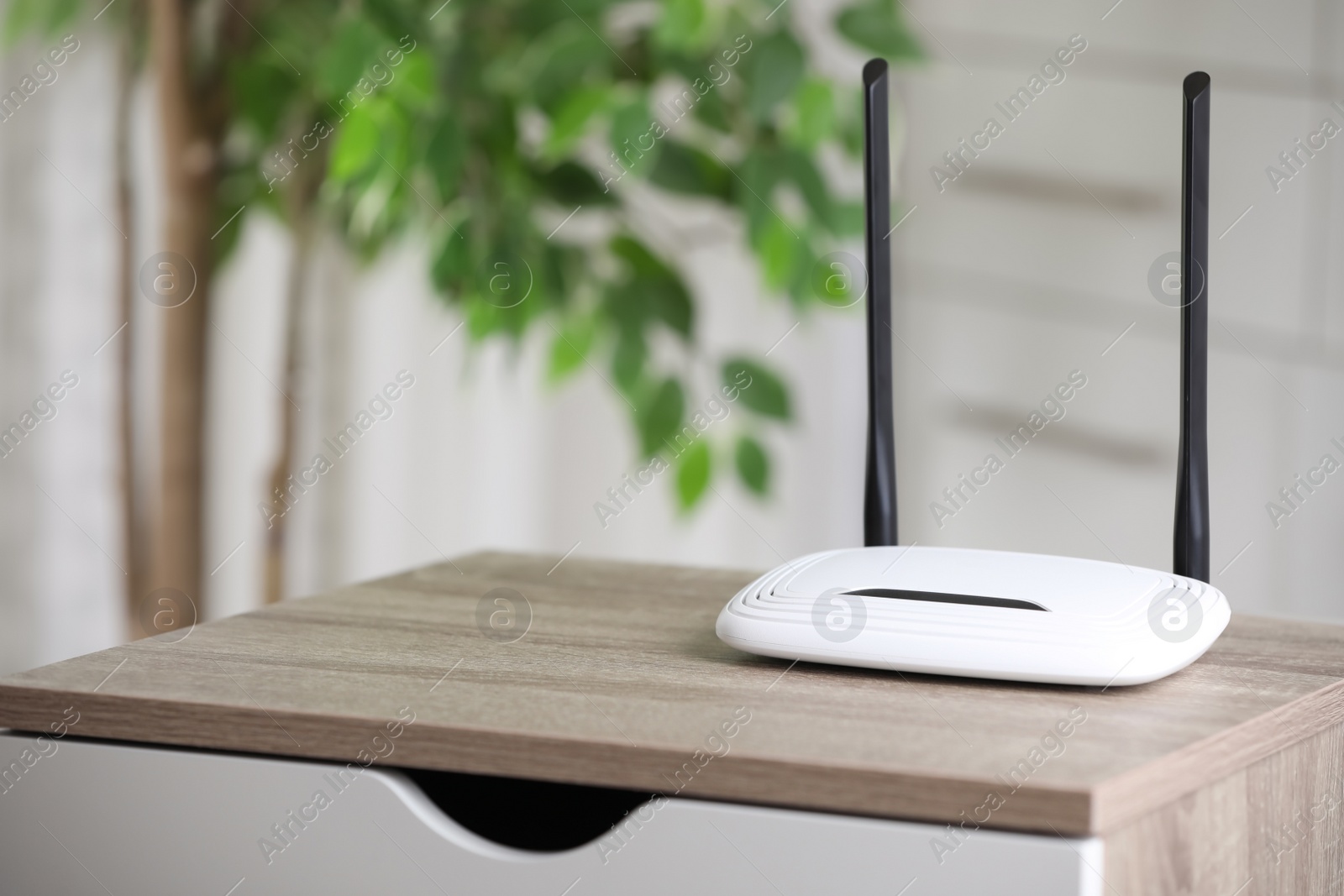 Photo of Modern Wi-Fi router indoors. Space for text