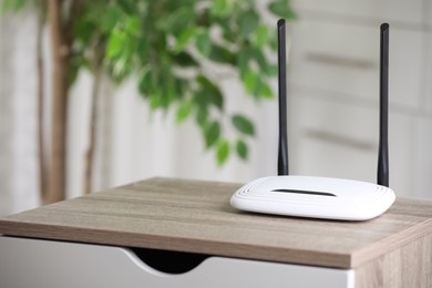 Photo of Modern Wi-Fi router indoors. Space for text