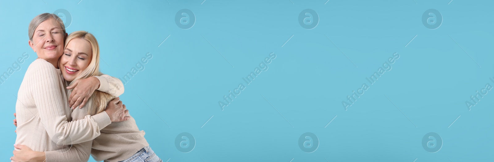 Image of Happy mother and daughter on light blue background, space for text. Banner design