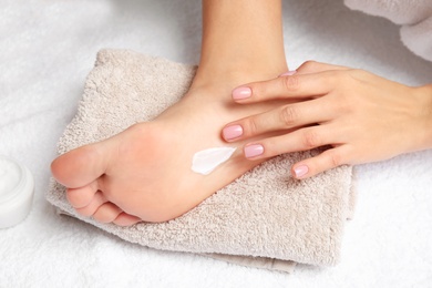 Photo of Woman with cream on her foot, closeup. Spa treatment