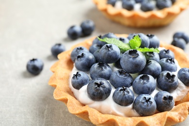 Photo of Delicious sweet pastry with berries on grey table, closeup