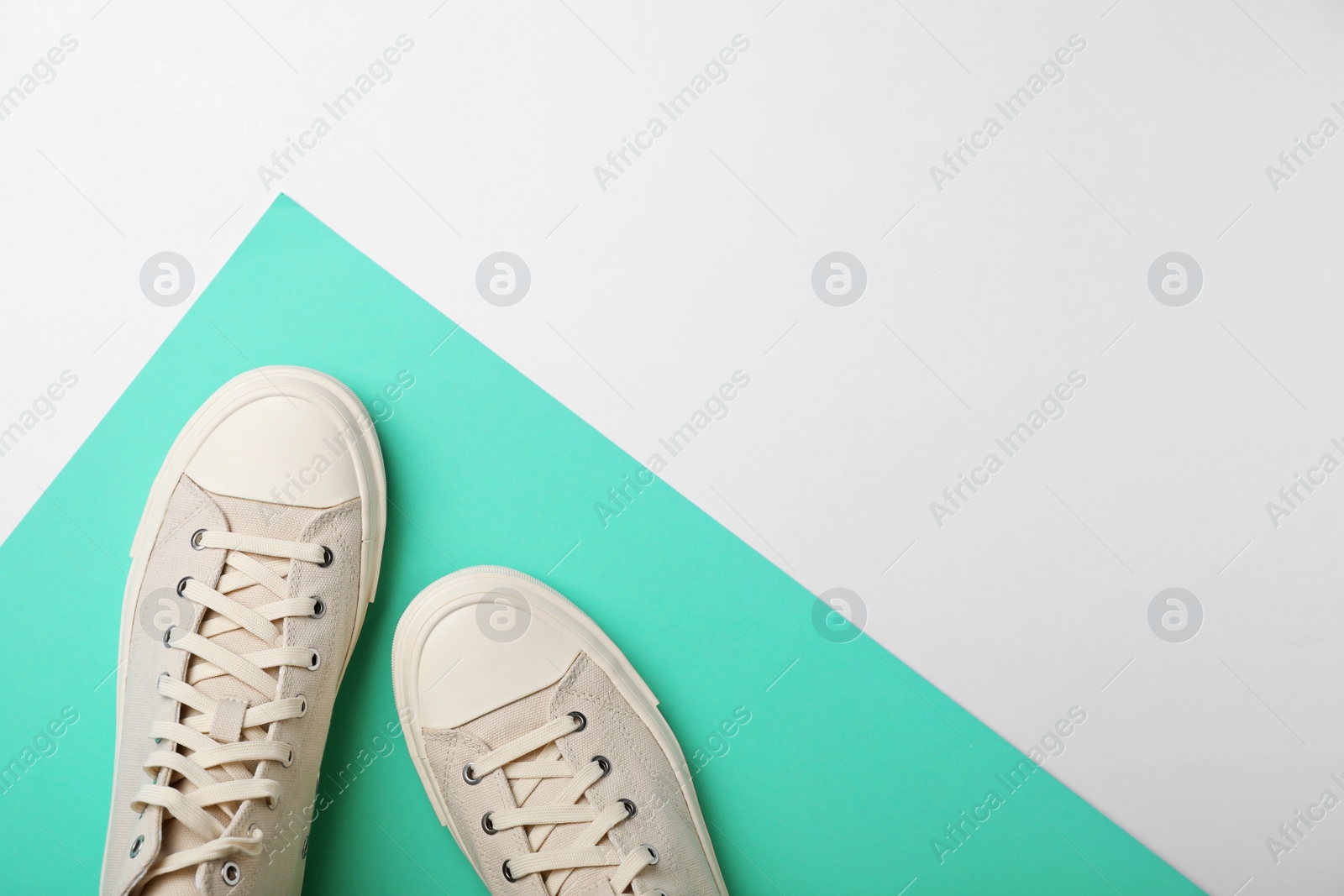 Photo of Pair of stylish sneakers on color background, top view