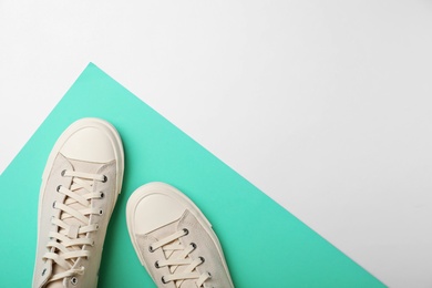 Photo of Pair of stylish sneakers on color background, top view