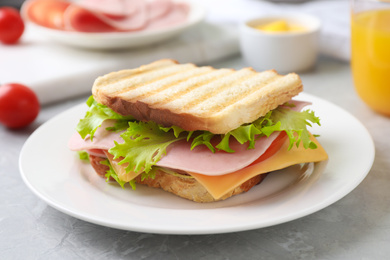 Photo of Tasty sandwich with ham on grey table