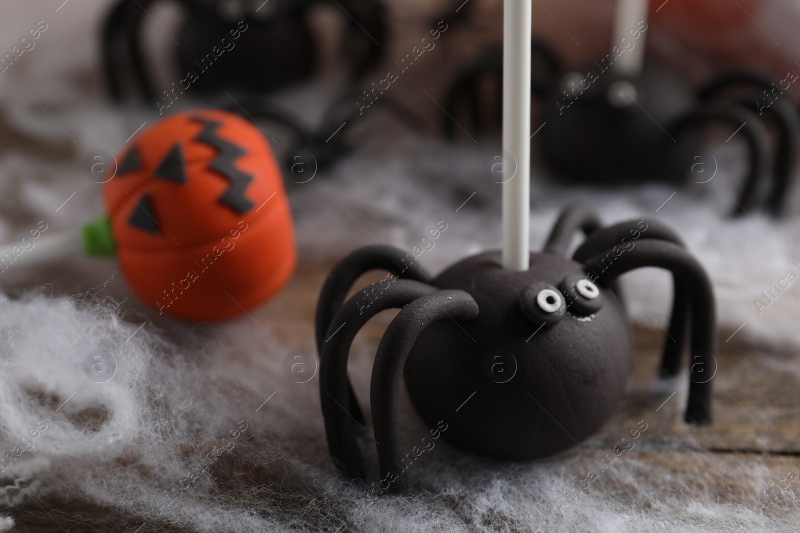 Photo of Different Halloween themed cake pops on wooden table, closeup