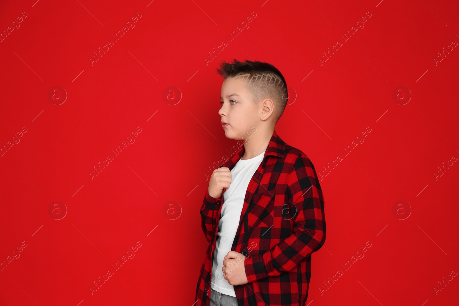 Photo of Portrait of cute little boy on red background