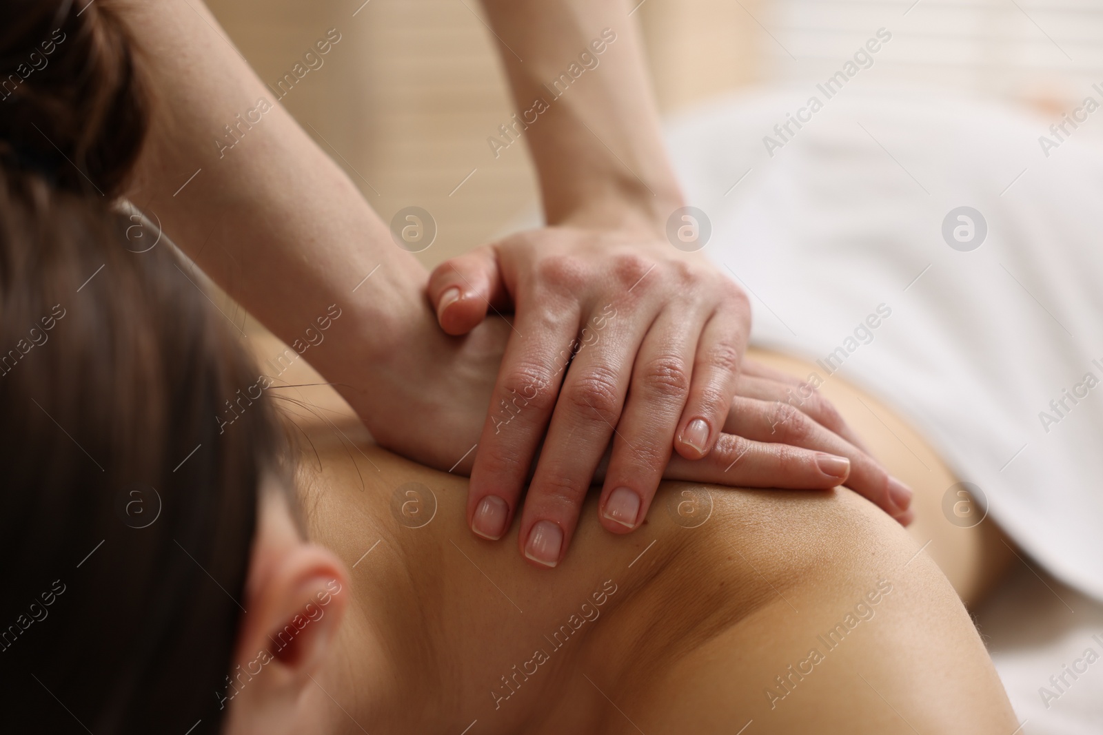 Photo of Woman receiving back massage in spa salon, closeup