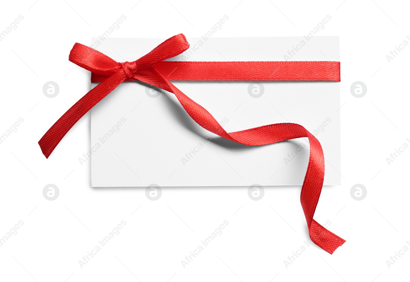 Photo of Blank gift tag with red satin ribbon on white background, top view