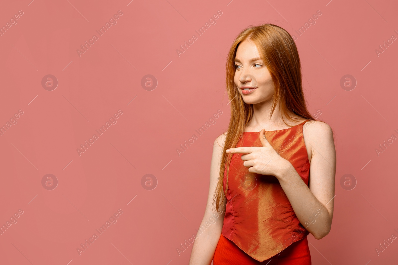 Photo of Portrait of beautiful young woman on pink background, space for text