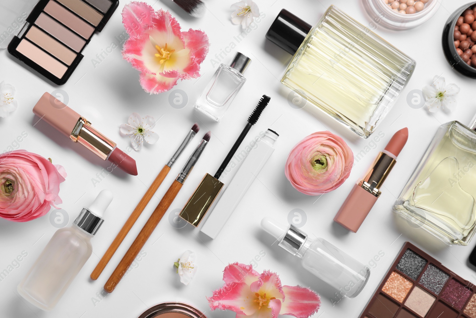 Photo of Flat lay composition with different makeup products and beautiful spring flowers on white background