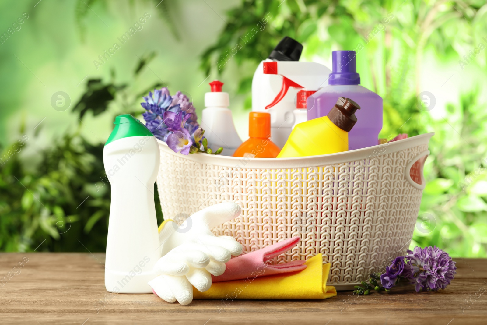 Photo of Spring flowers and cleaning supplies on wooden table