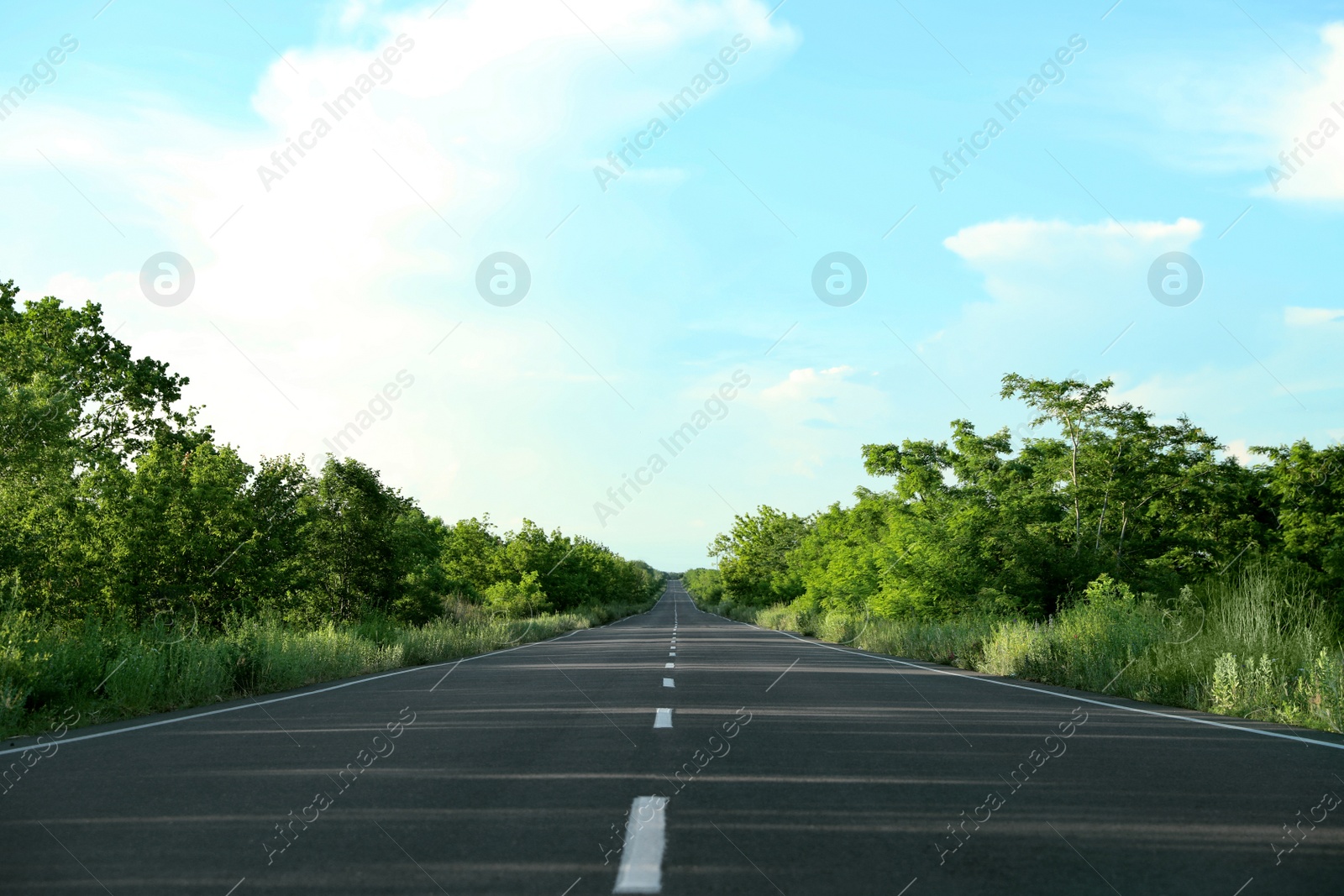 Photo of Asphalt road running through countryside on sunny day