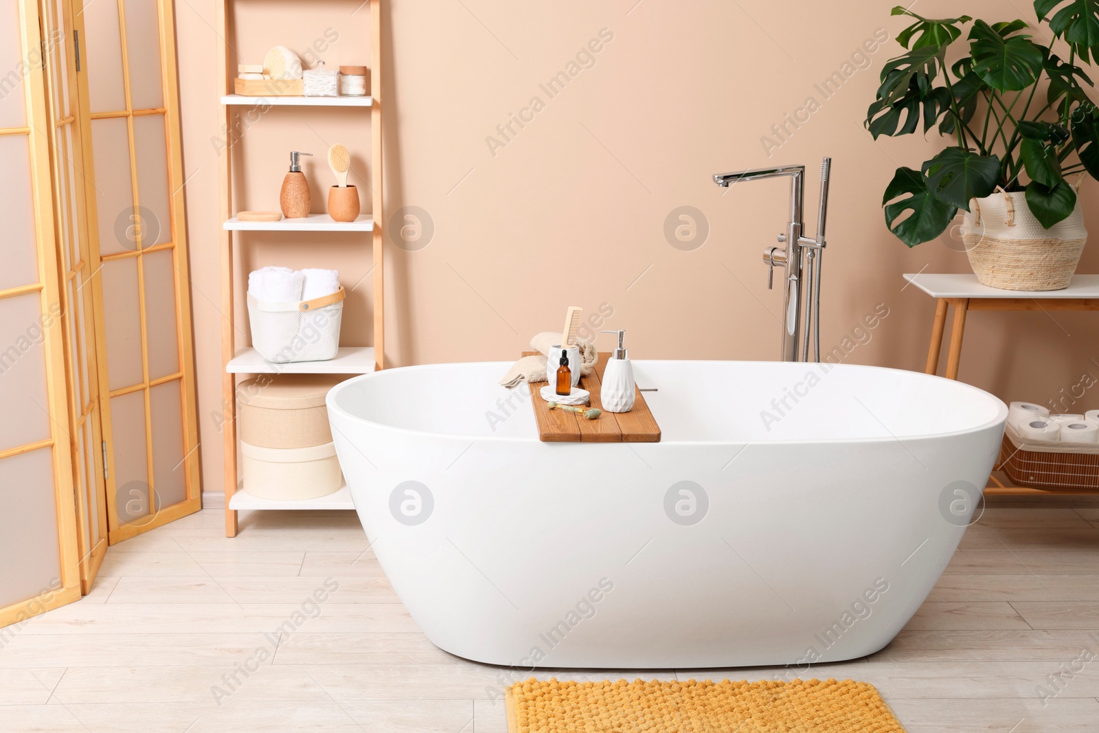 Photo of Different personal care products and accessories on bath tub in bathroom