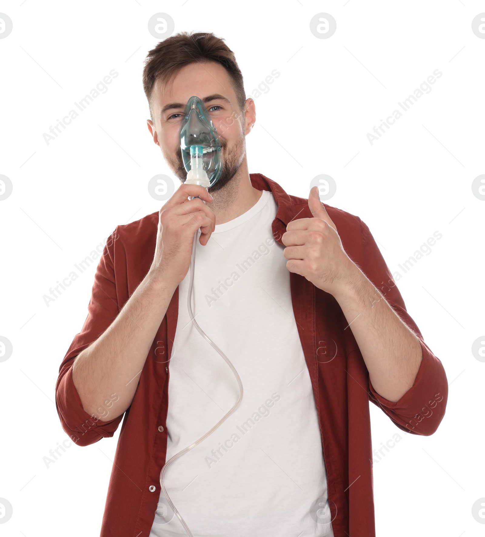 Photo of Man using nebulizer for inhalation and showing thumb up on white background