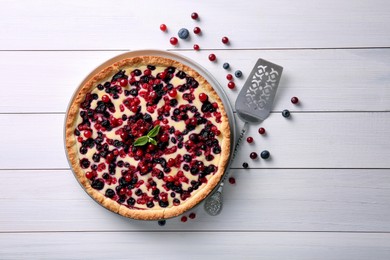 Photo of Delicious currant pie and fresh berries on white wooden table, flat lay