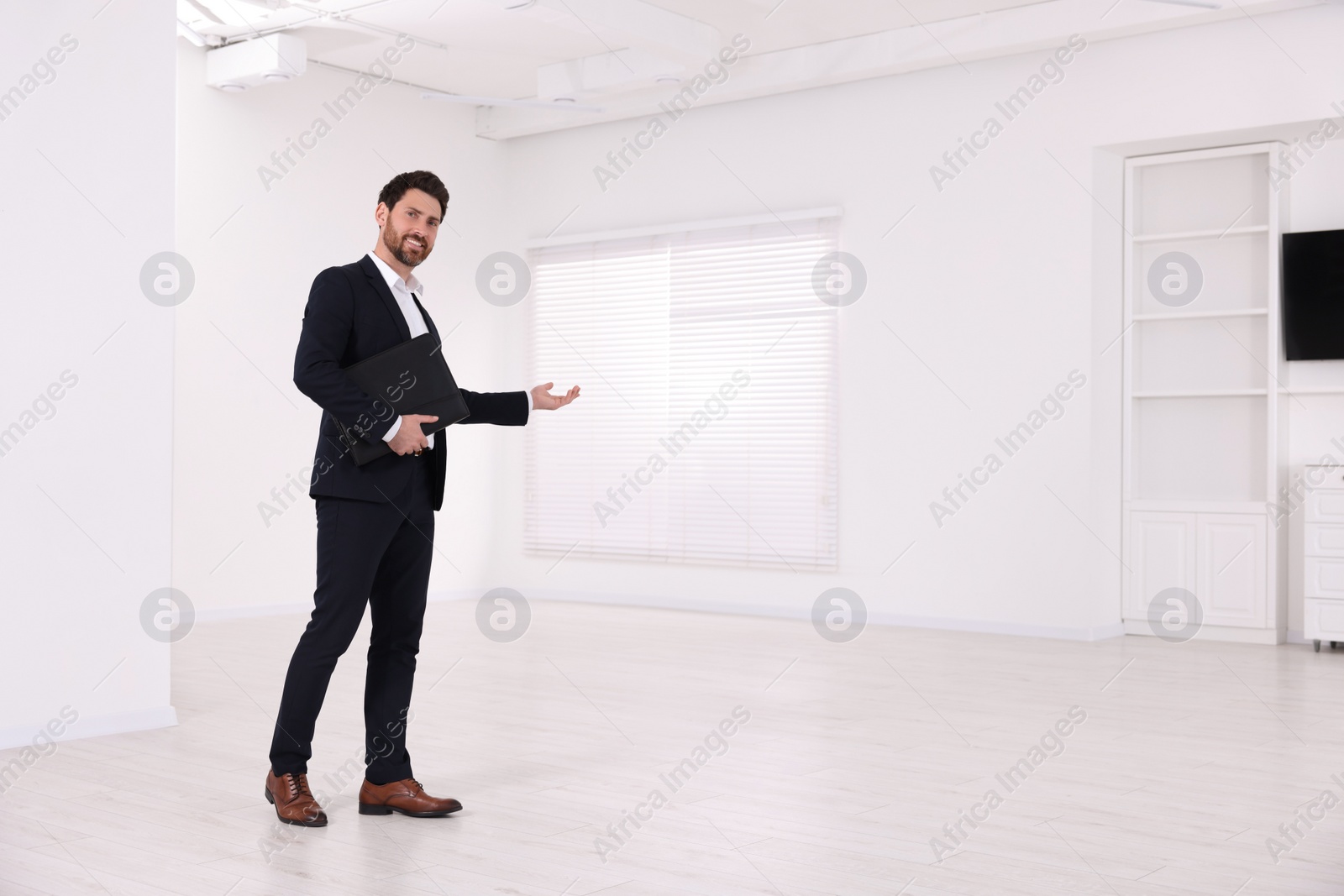 Photo of Happy real estate agent showing new apartment