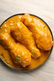 Tasty chicken curry on wooden table, top view