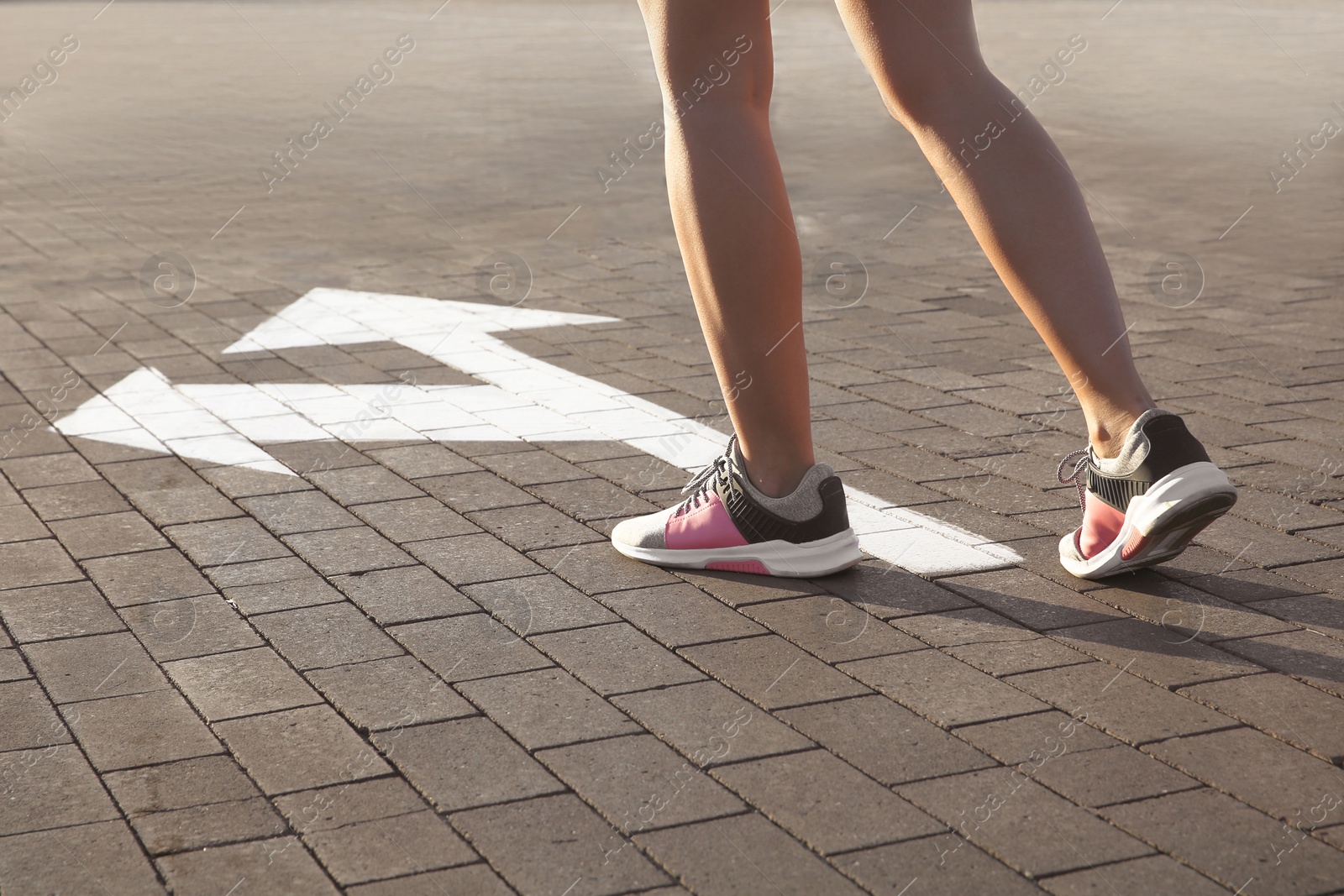 Photo of Woman going along road with arrows marking, closeup