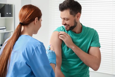 Doctor giving hepatitis vaccine to patient in clinic