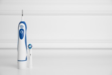 Photo of Electric toothbrush on white background, space for text