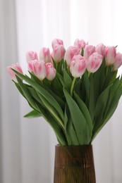 Beautiful bouquet of fresh pink tulips indoors