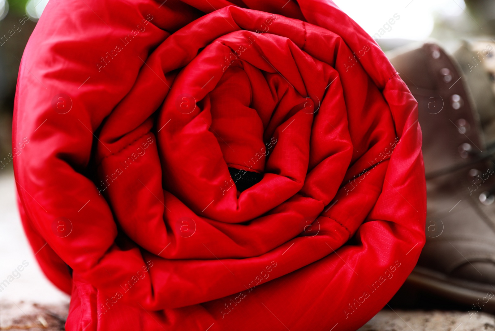 Photo of Rolled sleeping bag outdoors, closeup. Camping gear