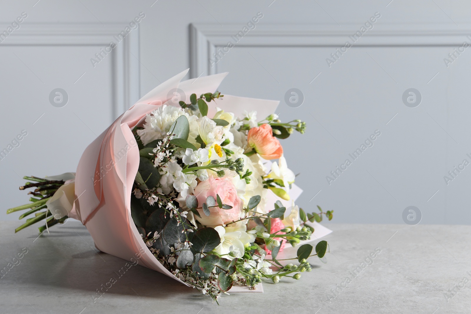 Photo of Bouquet of beautiful flowers on light grey table. Space for text