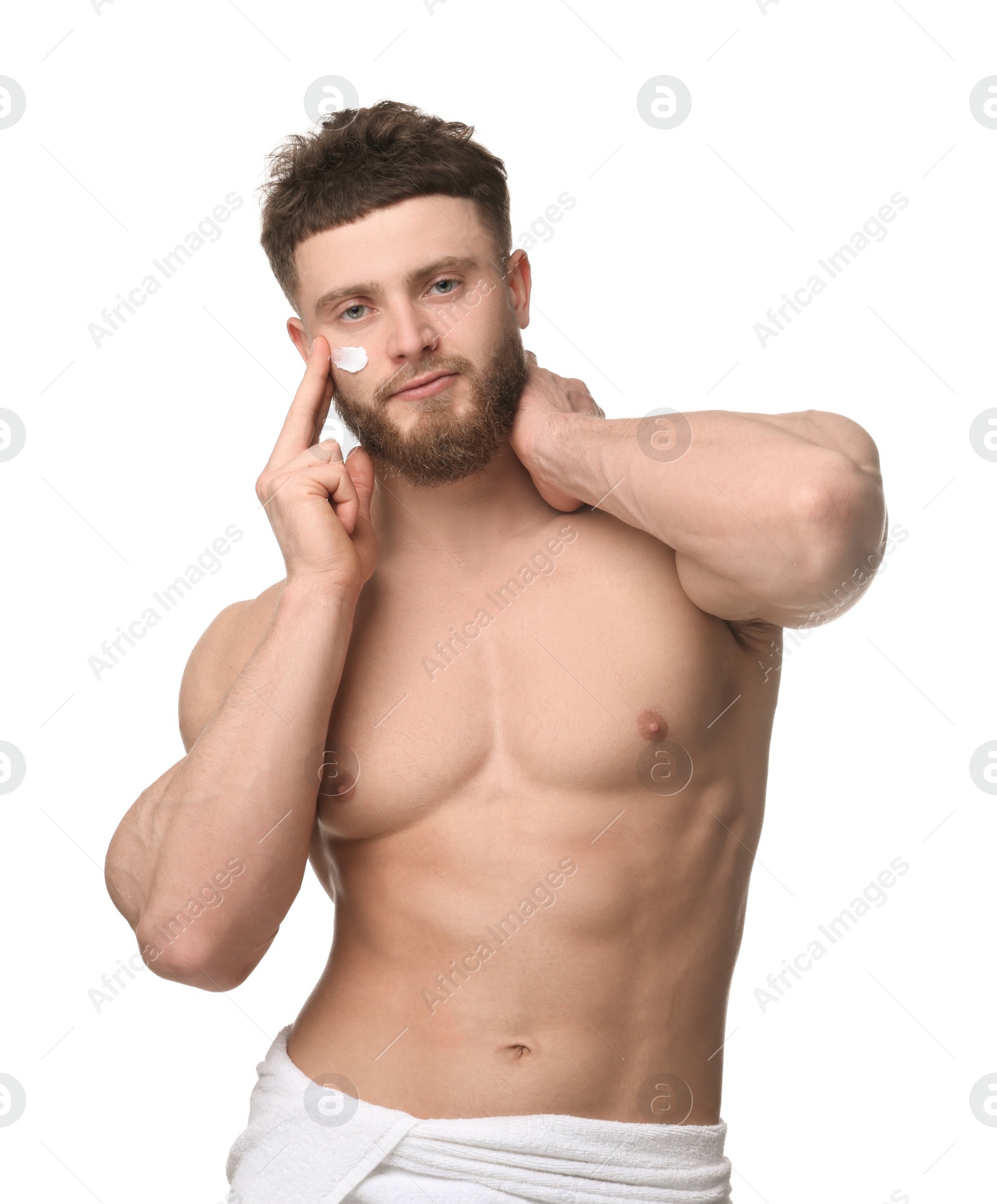 Photo of Handsome man applying moisturizing cream onto his face on white background