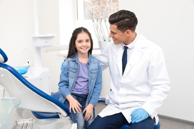 Photo of Professional dentist and little girl in clinic