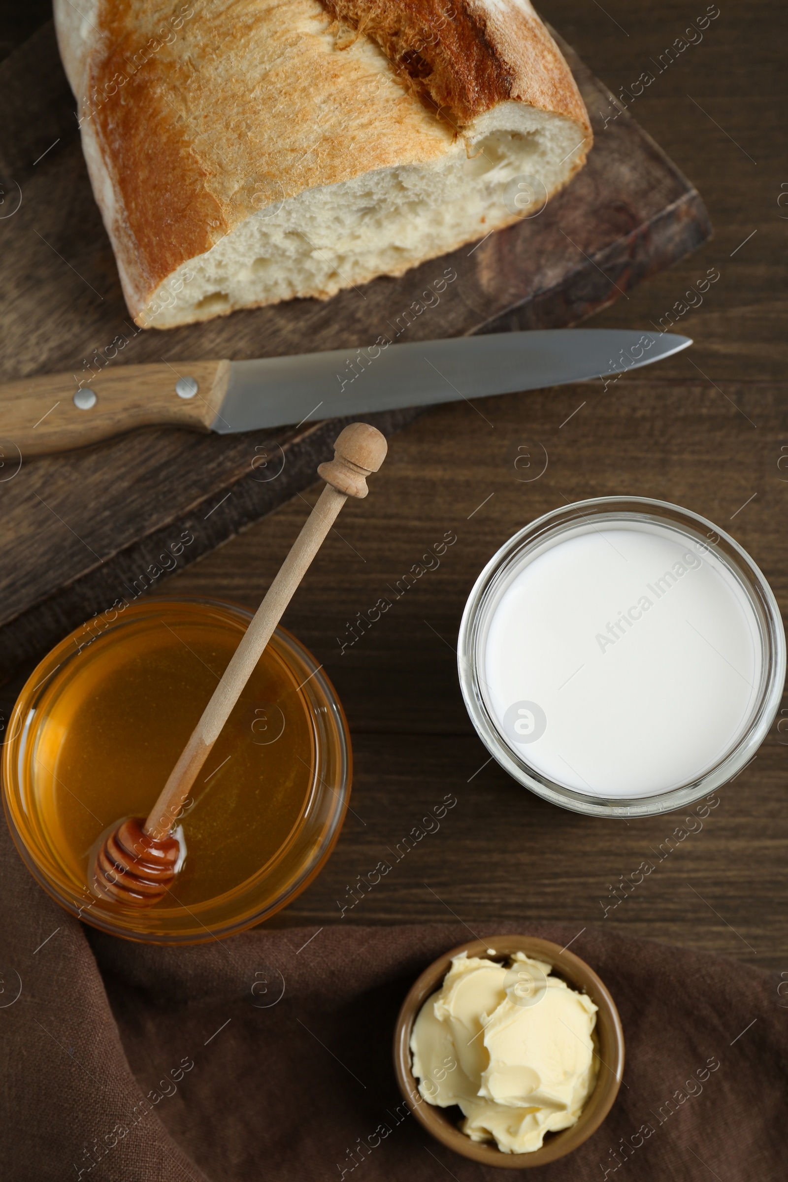 Photo of Flat lay composition of honey, milk and butter on wooden table