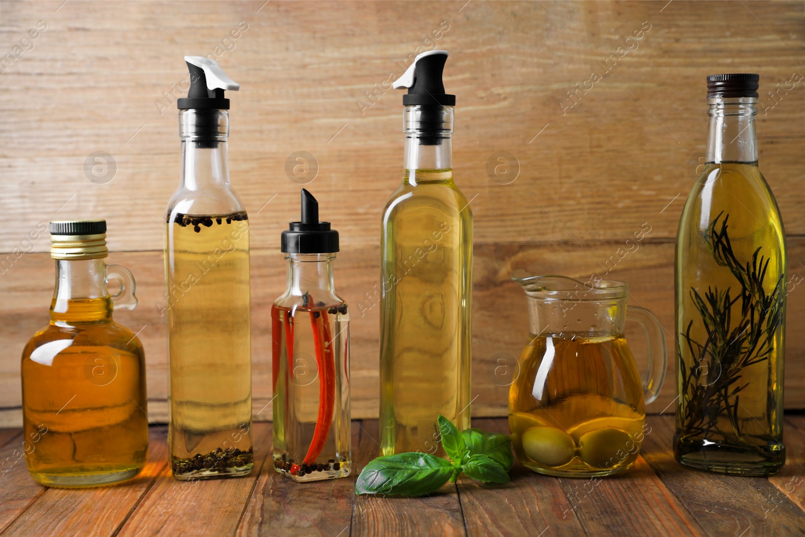 Photo of Many different cooking oils on wooden table
