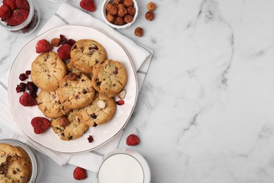 Photo of Cookies with freeze dried fruits, milk and nuts on white marble table, flat lay. Space for text