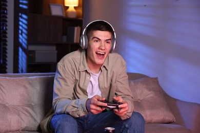 Photo of Man playing video games with controller at home