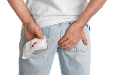 Photo of Man holding toilet paper with blood stain on white background, closeup. Hemorrhoid concept