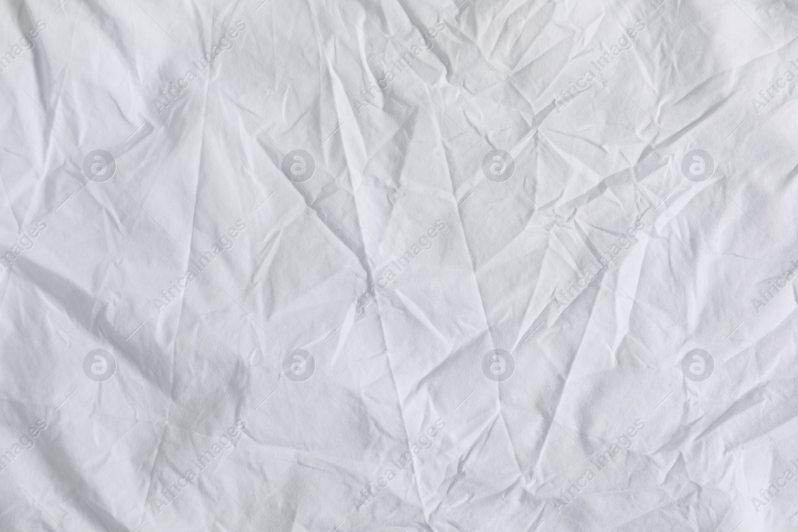 Photo of Crumpled white fabric as background, top view